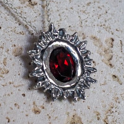 The Maker’s Pendant in Sol, set with a faceted garnet