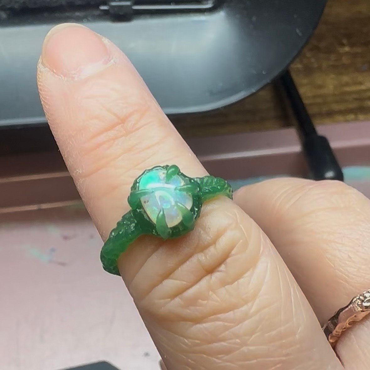 An opal ring shown in green wax before casting