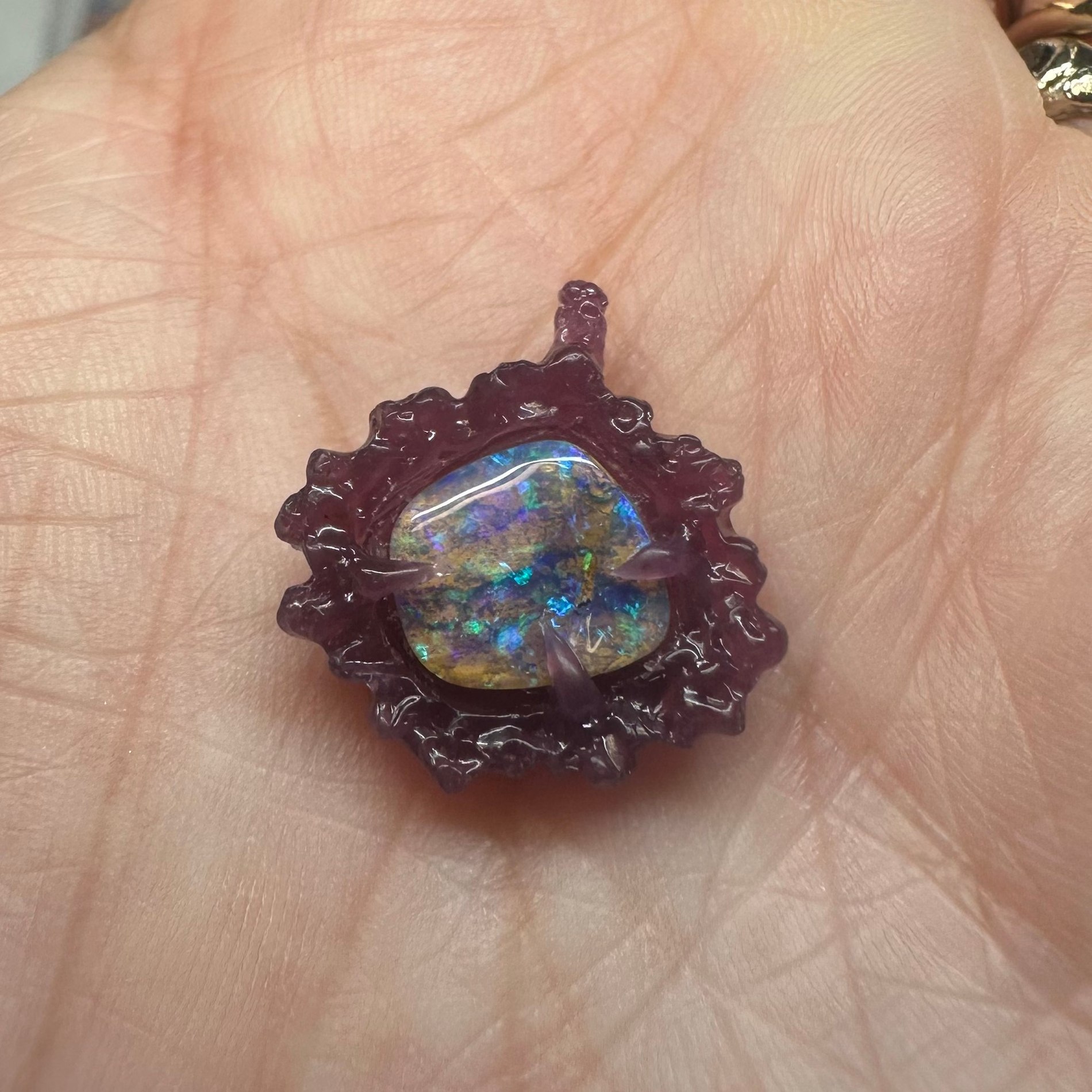 A sunburst-style opal pendant setting shown in wax before casting